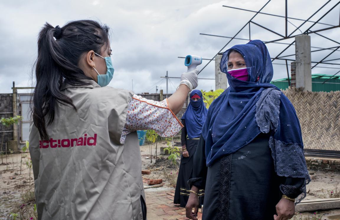 ActionAid worker Uthiya yea Marma is checking Anowara's body temperature before letting her enter inside ActionAid's women-friendly space.