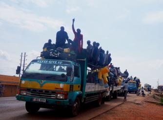 The photo shows members of the Apaa community on an open-top bus