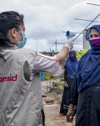 ActionAid worker Uthiya yea Marma is checking Anowara's body temperature before letting her enter inside ActionAid's women-friendly space.