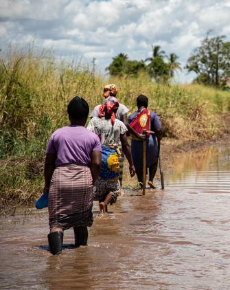 The all-women farmers association, Vamos Prouzir, walks through flooding to assess the damage done to their farmland in Buzi, Mozambique.